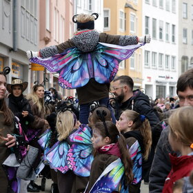 Eine bunte Menschengruppe in Kostümen. 