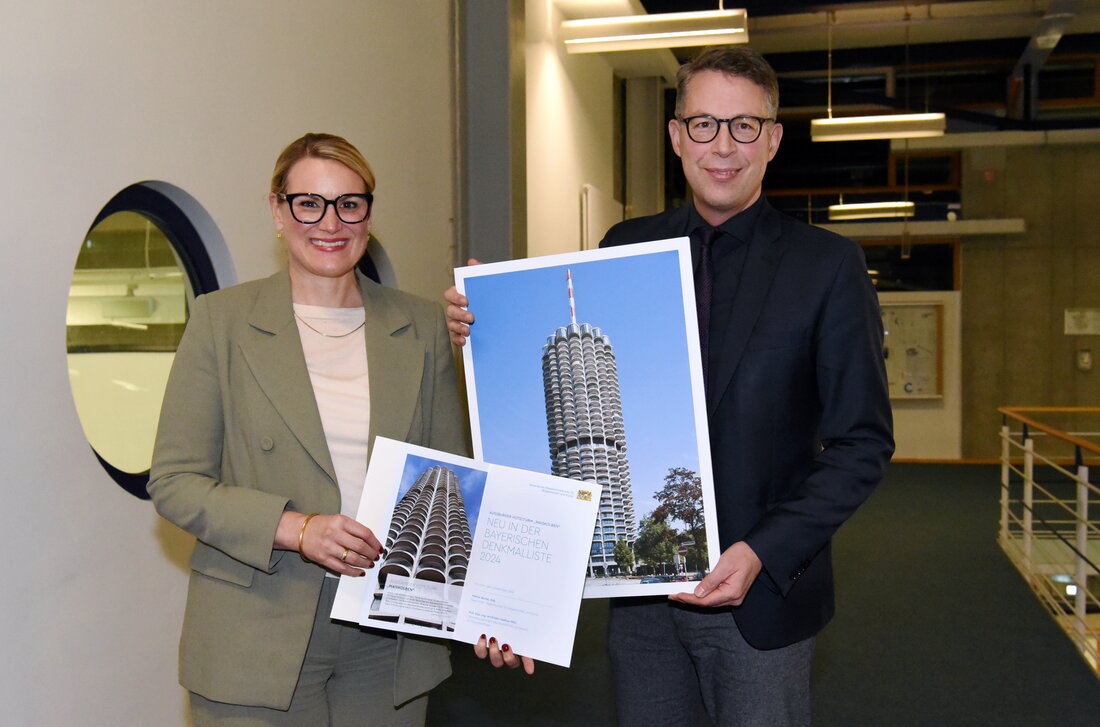 OB Eva Weber hält eine Urkunde in der Hand. Neben ihr ein Mann mit einem Bild des Hotelturms