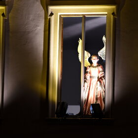 hell erleuchtete Fenster, an denen Engel stehen