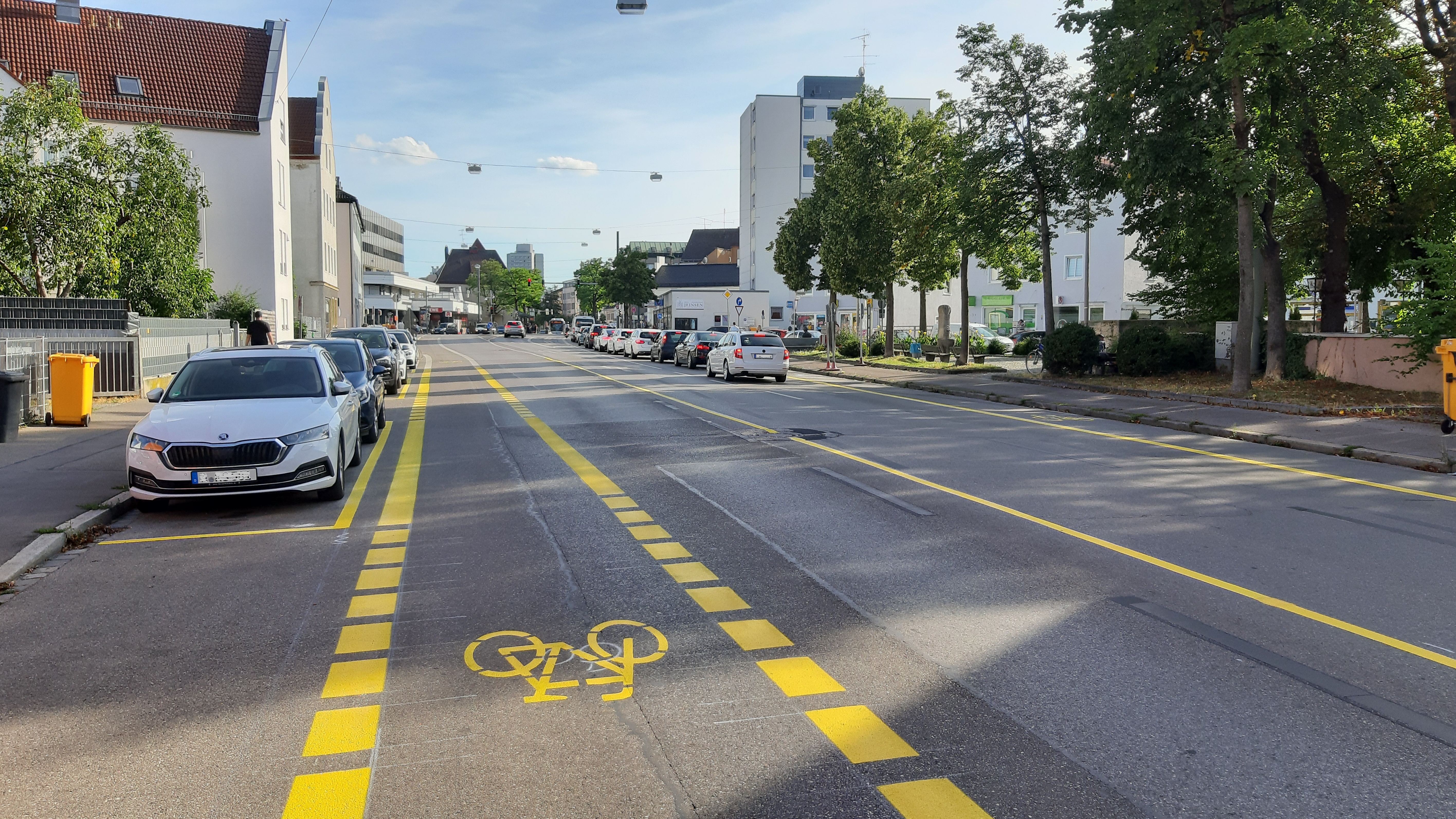 Gelbe Streifen auf einer Straße markieren einen Fahrradweg