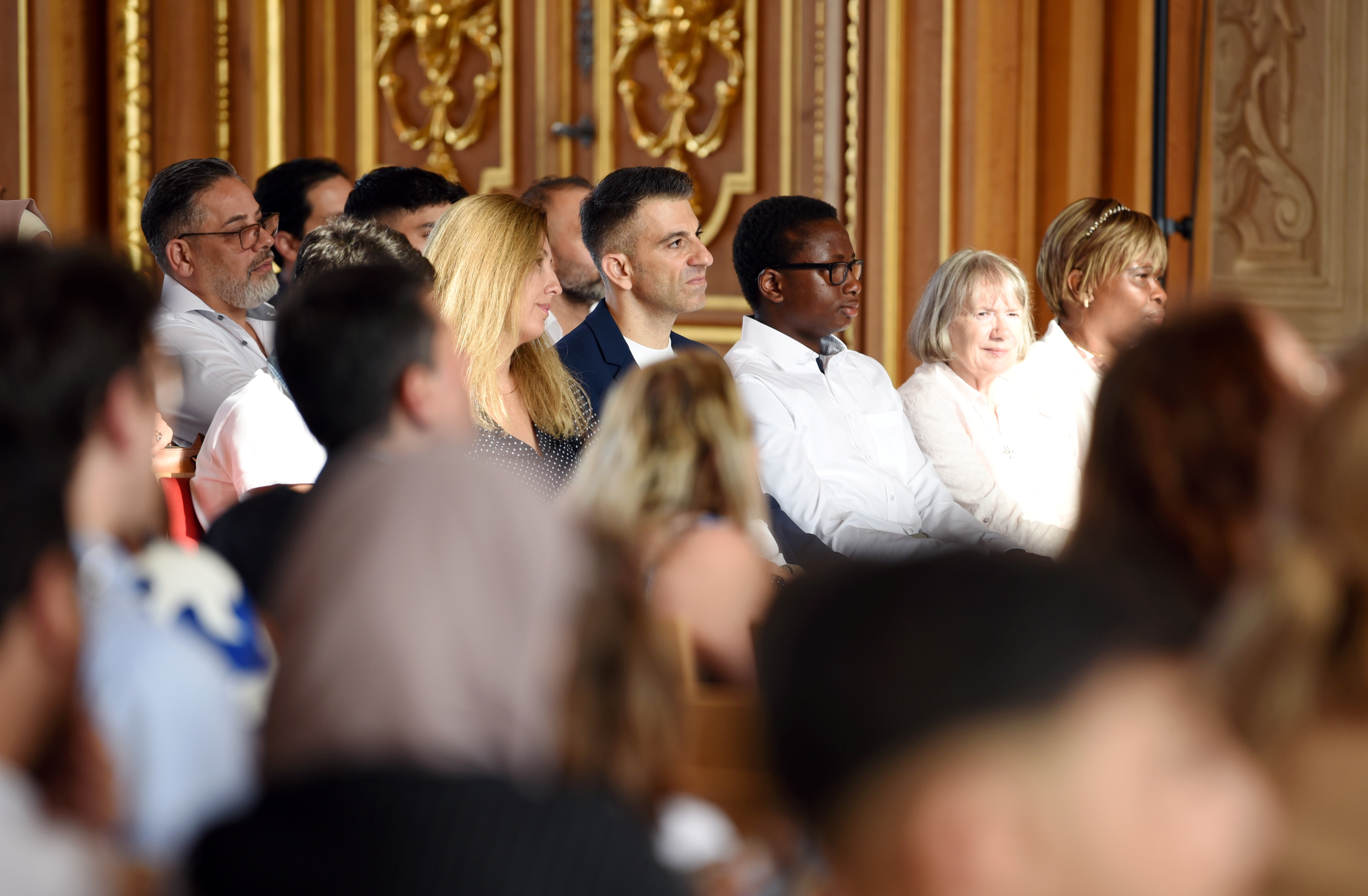 Menschen unterschiedlicher Hautfarben im Goldenen Saal des Rathauses