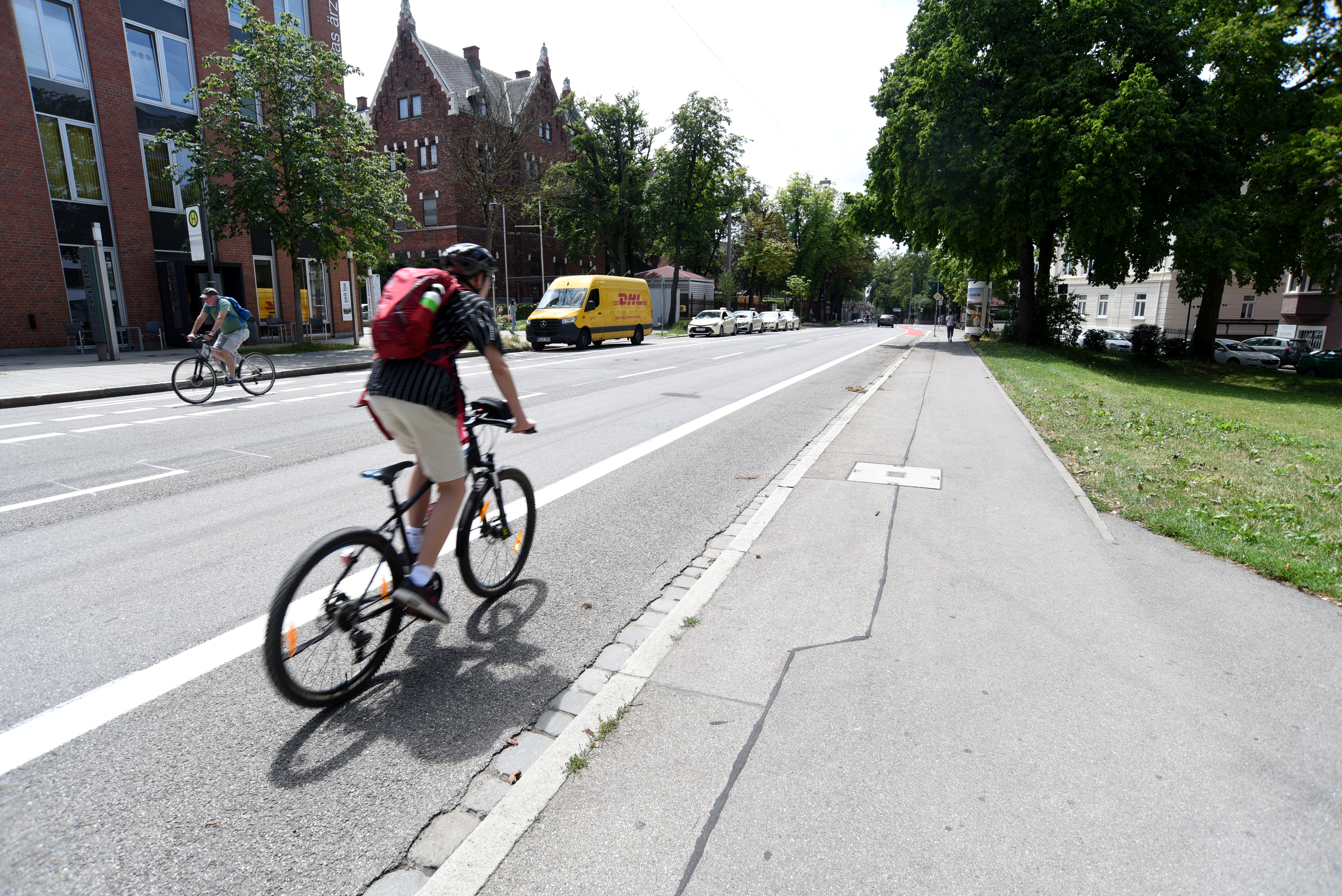 Ein Junge fährt mit dem Fahrrad auf einem markierten Fahrradstreifen neben einer Straße