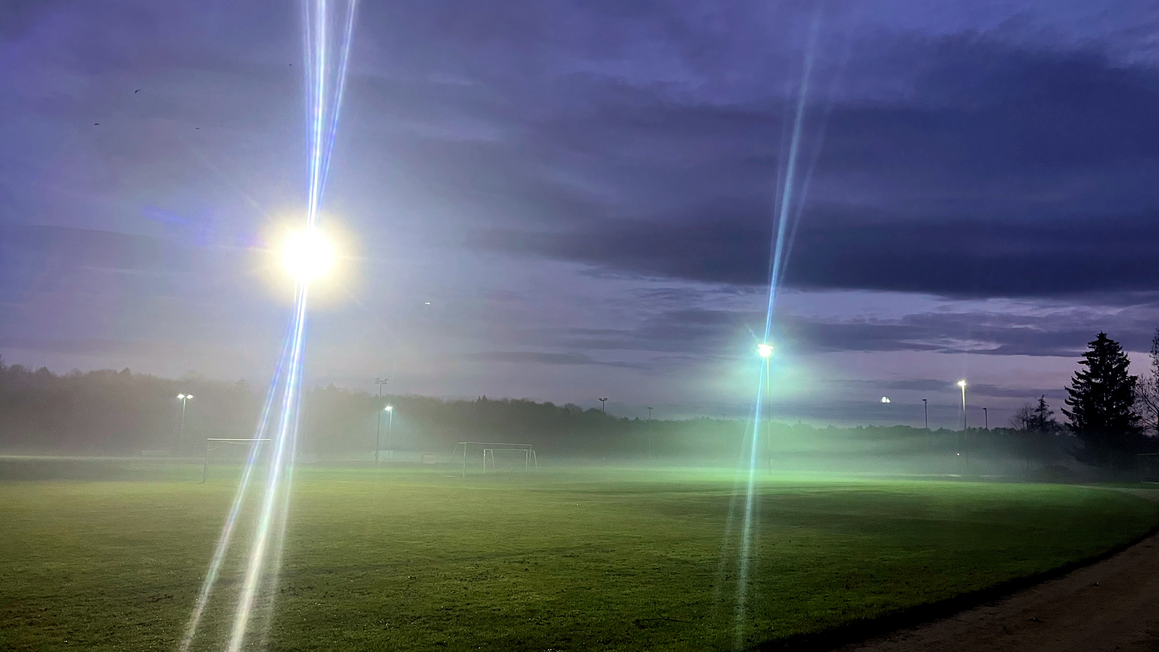 Die Sportanlage Süd bei Nacht. Es leuchten Lichter auf hohen Masten